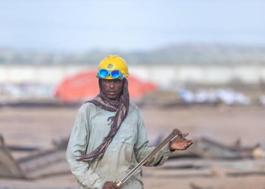 Gadani Pakistan Ağustos 2021, sarı kasklı bir işçi Gadani gemi hurdalığında metal levha kesiyor.