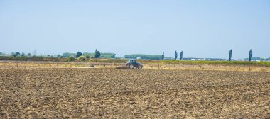 Farmer in tractor preparing land with seedbed cultivator in a farm