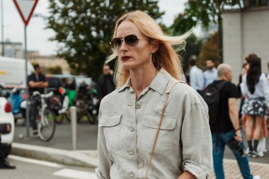 Misafir güneş gözlüğü, gri gömlek ve etek giyiyor, Milan Moda Haftası Kadın Giyim / Yaz 2024 boyunca PRADA gösterisinin dışında görülüyor.