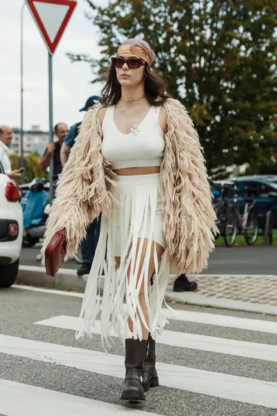 stock image A guest white top and skirt, beige shaggy knitted coat, black boots, seen outside PRADA show during Milan Fashion Week Womenswear Spring/Summer 2024.