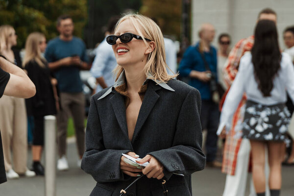 Виолетта Грейс Аткинсон в сером блейзере, сумка Prada, замечена за пределами шоу PRADA во время Миланской недели моды Женская одежда Весна / Лето 2024.