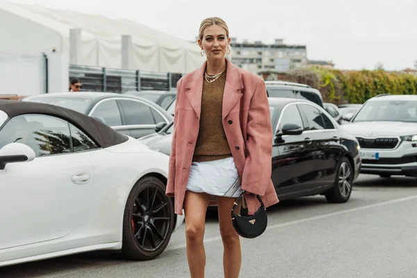 Emili Sindlev kolye takıyor, örgü kazak, büyük boy pembe süet ceket, Prada çanta, Milan Moda Haftası Kadın giyim / Yaz 2024 'te PRADA gösterisinin dışında görülüyor..