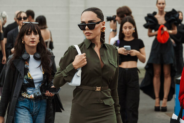 Evangelie Smyrniotaki носит черные солнцезащитные очки, золотые серьги, зеленые пуговицы платье видели на выставке PRADA во время недели моды в Милане Женская одежда Весна / Лето 2024.