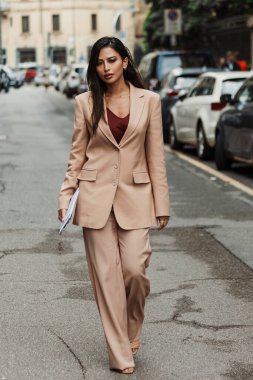 Milano Moda Haftası Kadın giyim / Yaz 2024 'te MAX MARA gösterisinin dışında kırmızı atlet ve bej bir takım elbise giyen bir konuk görülüyor..