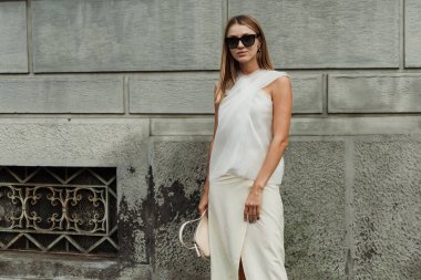 Misafir güneş gözlüğü, beyaz bluz, etek ve çanta takıyor, Milan Moda Haftası Kadın giyim / Yaz 2024 'te MAX MARA gösterisinin dışında görülüyor.