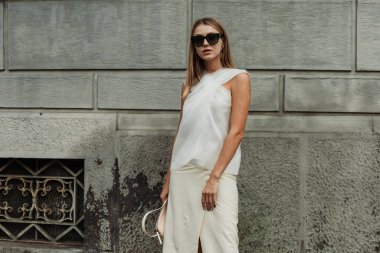 Misafir güneş gözlüğü, beyaz bluz, etek ve çanta takıyor, Milan Moda Haftası Kadın giyim / Yaz 2024 'te MAX MARA gösterisinin dışında görülüyor.