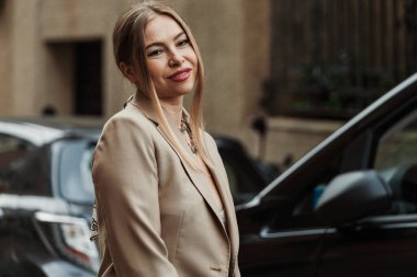 Misafir kolye takıyor, bej ceket, Milan Moda Haftası Kadın Giyim / Yaz 2024 'te MAX MARA gösterisinin dışında görülüyor..