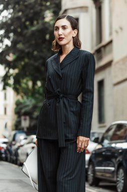 Misafir siyah çizgili takım elbise giyiyor, beyaz çanta, Milan Moda Haftası Kadın giyim / Yaz 2024 boyunca MAX MARA gösterisinin dışında görülüyor..