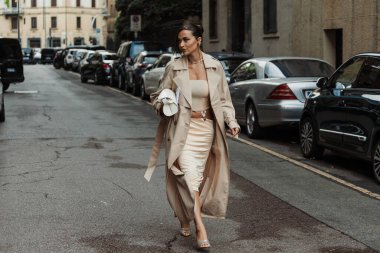 Giulia Gaudino açık bej bir siper, bej bir göbek üstü, bej ipek ipek bir etek, beyaz bir deri çanta ve gümüş topuklu ayakkabı giyiyor, Milan Moda Haftası Kadın Giyim Haftası Bahar / Yaz 2024 boyunca MAX MARA gösterisinin dışında görülüyor..