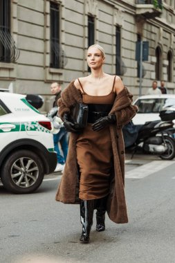 Leonie Hanne kahverengi elbise, siyah korse, eldiven, ayıcık ceket, vinil botlar giyer, Milan Moda Haftası Kadın giyim / Yaz 2024 'te MAX MARA gösterisinin dışında görülmüştür..