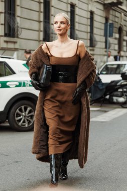 Leonie Hanne kahverengi elbise, siyah korse, eldiven, ayıcık ceket, vinil botlar giyer, Milan Moda Haftası Kadın giyim / Yaz 2024 'te MAX MARA gösterisinin dışında görülmüştür..