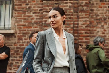 Paola Turani, Milan Moda Haftası Kadın Giyim / Yaz 2024 'te MAX MARA gösterisinin dışında gri takım elbise ve beyaz bluz giyer..