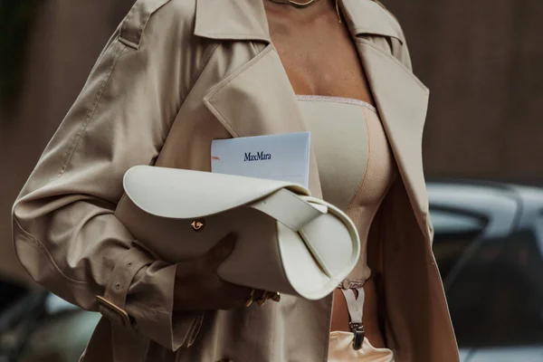 Moda detayları. Giulia Gaudino açık bej bir siper, bej bir göbek üstü, bej ipek ipek bir etek, beyaz bir deri çanta giyiyor, Milan Moda Haftası Kadın giyim / Yaz 2024 'te MAX MARA gösterisinin dışında görülüyor..