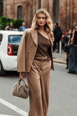 Chloe Lecareux bej bir takım elbise, gümüş ve altın bir halka gümüşü kahverengi bir omuz üstü, Max Mara kabarık bir çanta ve Milan Moda Haftası Kadın Giyimi İlkbahar / Yaz 2024 sırasında MAX MARA gösterisinin dışında görülen kahverengi kadife bir kemer giyiyor..