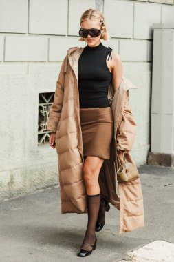 Misafir güneş gözlüğü takıyor, siyah kolsuz bluz, kahverengi mini etek, bej rengi ceket, siyah ayakkabılar, Milan Moda Haftası Kadın giyim / Yaz 2024 'te MAX MARA gösterisinin dışında görülüyor..