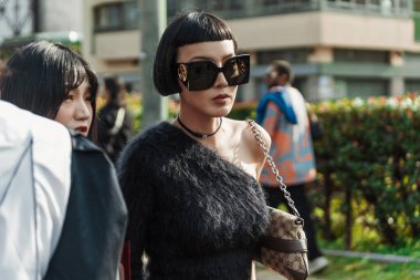 Kiwi Lee, Milan Moda Haftası Kadın Giyim / Yaz 2024 'te Gucci Show' un dışında siyah bir tek omuzlu üst, güneş gözlüğü, Gucci çanta giyer..