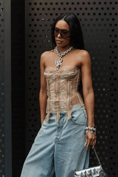 stock image Aleali May wears sunglasses, a chain necklace, off-shoulder top with ruffles, pale blue wide jeans, and a silver Gucci bag outside Gucci show during Milan Fashion Week Womenswear Spring/Summer 2024.