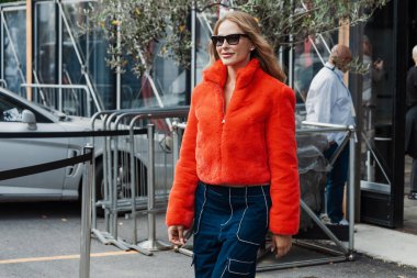 Ginta, Milan Moda Haftası Kadın Giyim / Yaz 2024 'te Antonio Marras' ın sergisinin önünde kırmızı kürk ceket giyiyor..