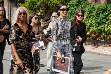 Olivia Valin (L) siyah ve kahverengi elbise giyer; Victoria Stella Doritou (R) Milan Moda Haftası Kadın giyim / Yaz 2024 'te Antonio Marras' ın gösterisi sırasında siyah ve beyaz bluz giyer..