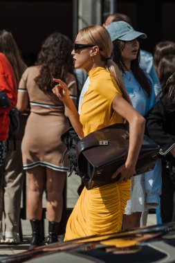 Niki Wu Jie, Milan Moda Haftası Kadın Giyim / Yaz 2024 'te Salvatore Ferragamo' nun önünde sarı elbise giyiyor..