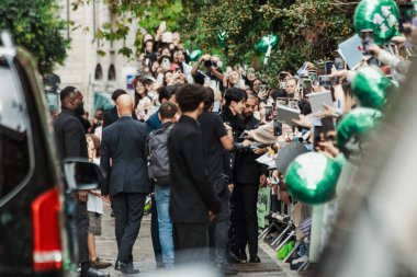 SEVENTEEN 'den DK / Dokyeom hayranlarıyla birlikte Milano Moda Haftası Kadın Giyim / Yaz 2024 boyunca Bally Show' un önünde.