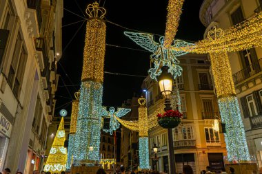 MALAGA, İspanya - 23 Aralık 2022: 23 Aralık 2022 'de İspanya' nın Malaga kentindeki Anayasa Meydanı 'nda Noel Ağacı yakınında kırmızı çiçekler