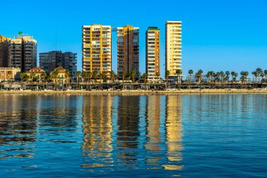 MALAGA, SPAIN - JANUARY 14, 2023: Buildings reflected in blue water in port in Malaga, Spain on January 14, 2023