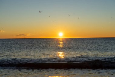 Airplane landing at sunrise over Mediterranean Sea, Costa del Sol, Malaga, Spain