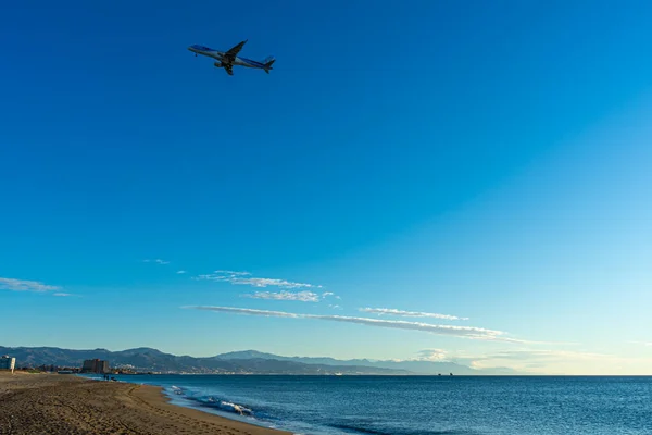 MALAGA, İspanya - 21 Ocak 2023: Akdeniz üzerinde gün doğumunda iniş yapan uçak, Costa del Sol, Malaga, İspanya 21 Ocak 2023