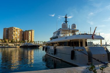 MALAGA, SPAIN - JANUARY 14, 2023: Yacht on sunset in port in Malaga, Spain on January 14, 2023