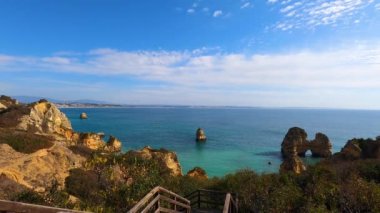 Kayalık uçurum kıyıları ve dalgaların üzerine çöktüğü cennet manzarası. Lagos 'taki Camillo plajı. Portekiz 'in güneyindeki Algarve bölgesinin Batı Atlantik kıyıları.