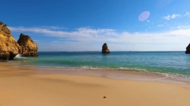 Kayalık uçurum kıyıları ve dalgaların üzerine çöktüğü cennet manzarası. Lagos 'taki Camillo plajı. Portekiz 'in güneyindeki Algarve bölgesinin Batı Atlantik kıyıları.