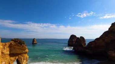 Kayalık uçurum kıyıları ve dalgaların üzerine çöktüğü cennet manzarası. Lagos 'taki Camillo plajı. Portekiz 'in güneyindeki Algarve bölgesinin Batı Atlantik kıyıları.