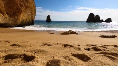 Kayalık uçurum kıyıları ve dalgaların üzerine çöktüğü cennet manzarası. Lagos 'taki Camillo plajı. Portekiz 'in güneyindeki Algarve bölgesinin Batı Atlantik kıyıları.