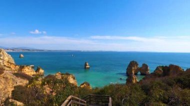 Kayalık uçurum kıyıları ve dalgaların üzerine çöktüğü cennet manzarası. Lagos 'taki Camillo plajı. Portekiz 'in güneyindeki Algarve bölgesinin Batı Atlantik kıyıları.