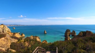 Kayalık uçurum kıyıları ve dalgaların üzerine çöktüğü cennet manzarası. Lagos 'taki Camillo plajı. Portekiz 'in güneyindeki Algarve bölgesinin Batı Atlantik kıyıları.