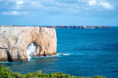 Kayalık uçurum kıyıları ve dalgaların üzerine çöktüğü cennet manzarası. Sagres yakınlarındaki kayalar. Portekiz 'in güneyindeki Algarve bölgesinin Batı Atlantik kıyıları.