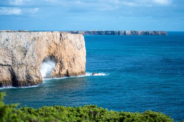 Kayalık uçurum kıyıları ve dalgaların üzerine çöktüğü cennet manzarası. Sagres yakınlarındaki kayalar. Portekiz 'in güneyindeki Algarve bölgesinin Batı Atlantik kıyıları.