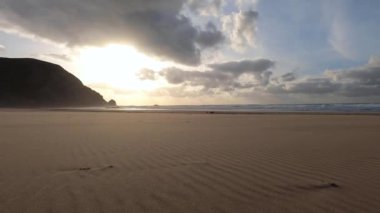 Kayalık uçurum kıyıları ve dalgaların üzerine çöktüğü cennet manzarası. Sörfçü Praia do Castelejo 'daki kayalar Sagres yakınlarında. Portekiz 'in güneyindeki Algarve bölgesinin Batı Atlantik kıyıları.