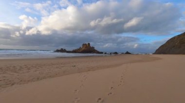 Kayalık uçurum kıyıları ve dalgaların üzerine çöktüğü cennet manzarası. Sörfçü Praia do Castelejo 'daki kayalar Sagres yakınlarında. Portekiz 'in güneyindeki Algarve bölgesinin Batı Atlantik kıyıları.