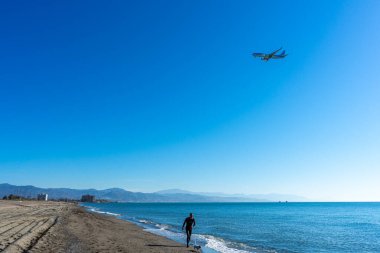 MALAGA, İspanya - 25 Mart 2023: Akdeniz üzerinde gün doğumunda iniş yapan uçak, Costa del Sol, Malaga, İspanya 25 Mart 2023