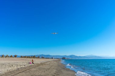 MALAGA, İspanya - 25 Mart 2023: Akdeniz üzerinde gün doğumunda iniş yapan uçak, Costa del Sol, Malaga, İspanya 25 Mart 2023