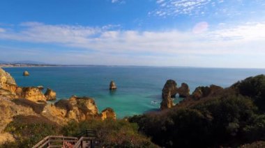 Kayalık uçurum kıyıları ve dalgaların üzerine çöktüğü cennet manzarası. Lagos 'taki Camillo plajı. Portekiz 'in güneyindeki Algarve bölgesinin Batı Atlantik kıyıları.