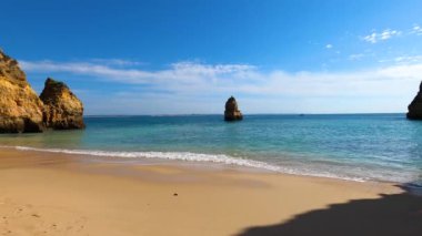 Kayalık uçurum kıyıları ve dalgaların üzerine çöktüğü cennet manzarası. Lagos 'taki Camillo plajı. Portekiz 'in güneyindeki Algarve bölgesinin Batı Atlantik kıyıları.