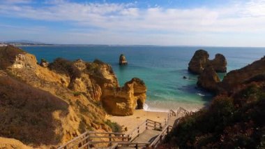 Kayalık uçurum kıyıları ve dalgaların üzerine çöktüğü cennet manzarası. Lagos 'taki Camillo plajı. Portekiz 'in güneyindeki Algarve bölgesinin Batı Atlantik kıyıları.