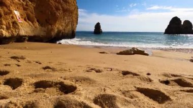 Kayalık uçurum kıyıları ve dalgaların üzerine çöktüğü cennet manzarası. Lagos 'taki Camillo plajı. Portekiz 'in güneyindeki Algarve bölgesinin Batı Atlantik kıyıları.