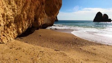 Kayalık uçurum kıyıları ve dalgaların üzerine çöktüğü cennet manzarası. Lagos 'taki Camillo plajı. Portekiz 'in güneyindeki Algarve bölgesinin Batı Atlantik kıyıları.