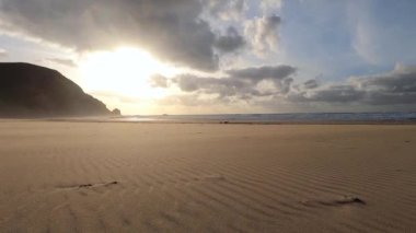Kayalık uçurum kıyıları ve dalgaların üzerine çöktüğü cennet manzarası. Sörfçü Praia do Castelejo 'daki kayalar Sagres yakınlarında. Portekiz 'in güneyindeki Algarve bölgesinin Batı Atlantik kıyıları.
