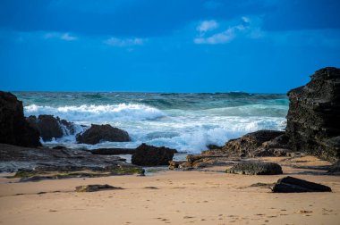 Kayalık uçurum kıyıları ve dalgaların üzerine çöktüğü cennet manzarası. Sagres yakınlarındaki kayalar. Portekiz 'in güneyindeki Algarve bölgesinin Batı Atlantik kıyıları.