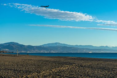 MALAGA, SPAIN - JANUARY 21, 2023: Airplane landing at sunrise over Mediterranean Sea, Costa del Sol in Malaga, Spain on January 21, 2023